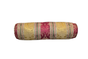 Decorative cylindrical bolster with multicoloures pattern on a yellow background.